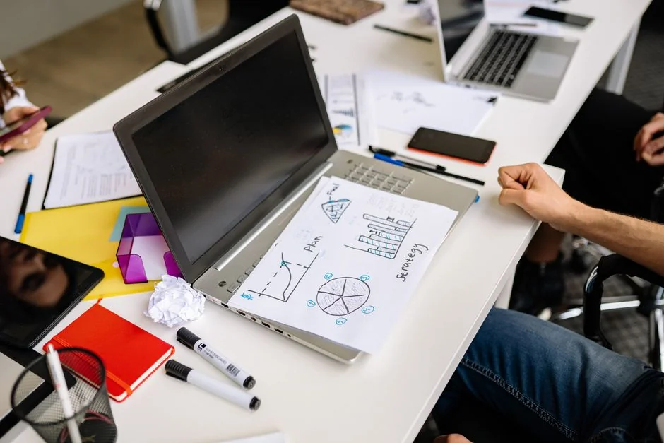 Deux professionnels en entreprise analysant les tendances du marché sur des appareils numériques dans un bureau.